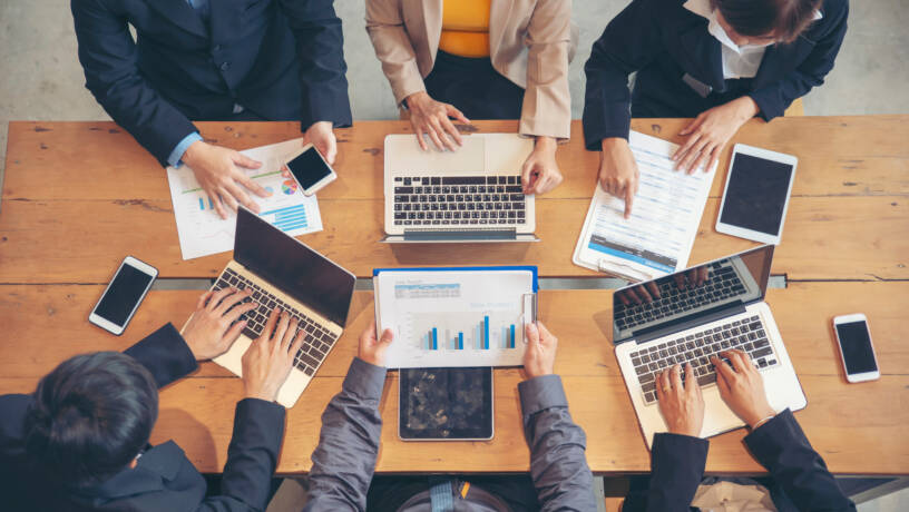 Senior professionals reviewing performance data and workforce metrics in a collaborative setting, reflecting the analytical approach required for effective hiring in Belfast’s 2026 talent market. Employers must increasingly rely on data-driven insight to align recruitment strategy with business growth objectives.