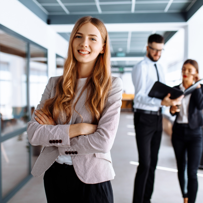 Executive assistant standing confidently in modern office environment