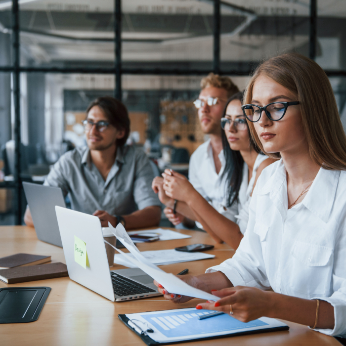 Business team analysing documents and performance data in a contemporary meeting space, reflecting the strategic workforce planning required in Belfast’s competitive 2026 hiring landscape. Employers must adopt data-led recruitment decisions, strengthen retention initiatives and align hiring strategies with long-term business growth.