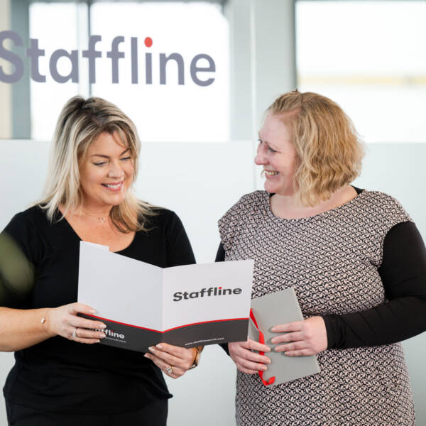 Two Staffline team members viewing a Staffline booklet together