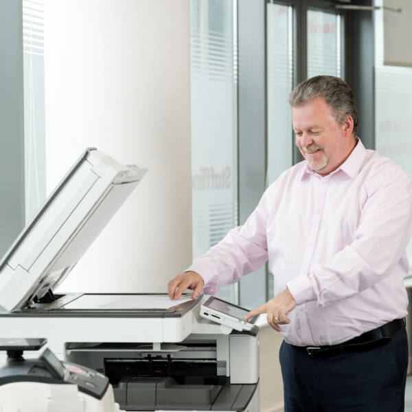 Staffline team member smiling while using a photocopier