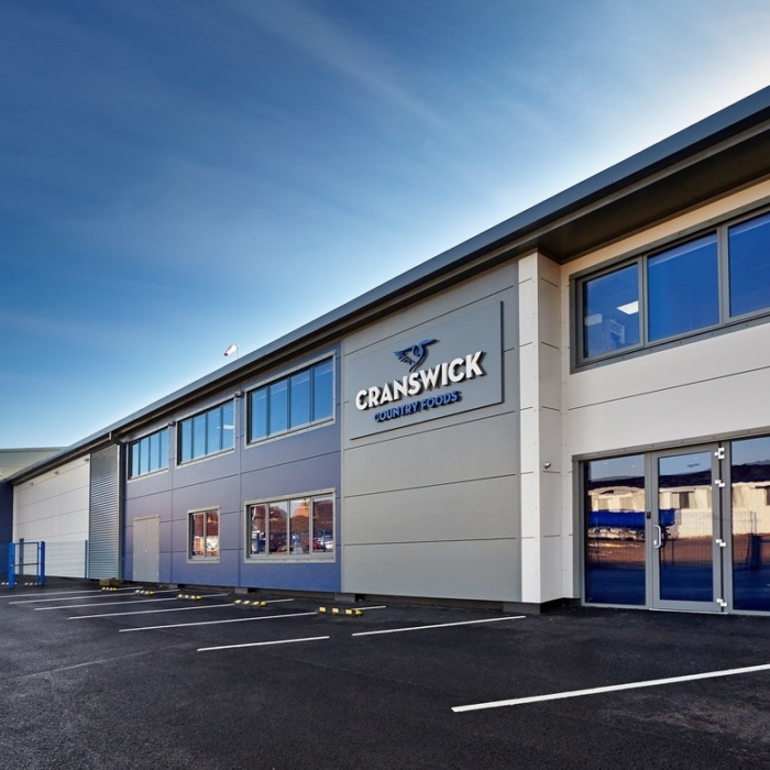 Exterior view of a Cranswick Country Foods facility, showcasing a modern workplace environment and the scale of operations.