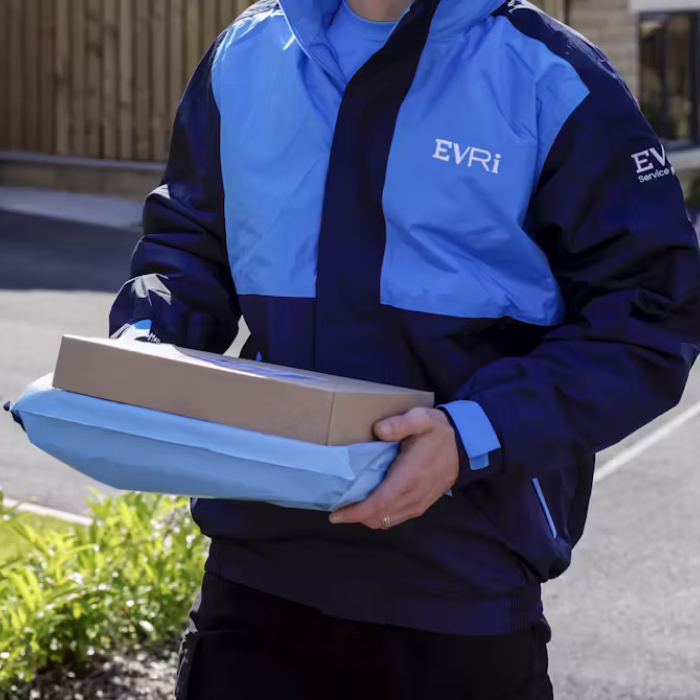 Two team members at work in an Evri warehouse, sorting parcels and preparing deliveries at the newly refurbished Mallusk site.