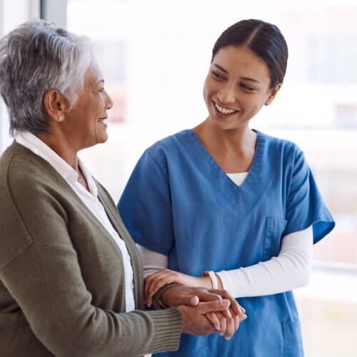 Medical professional smiling while holding a patient's arm