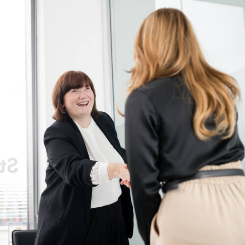 Two women greeting each other with a handshake