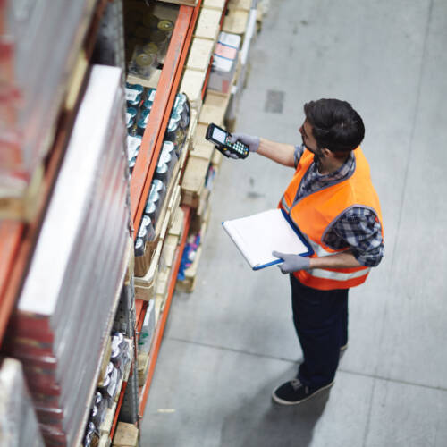 Warehouse worker checking stock and wearing a high-vis vest