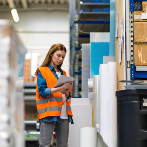 Woman in high-vis vest working in warehouse